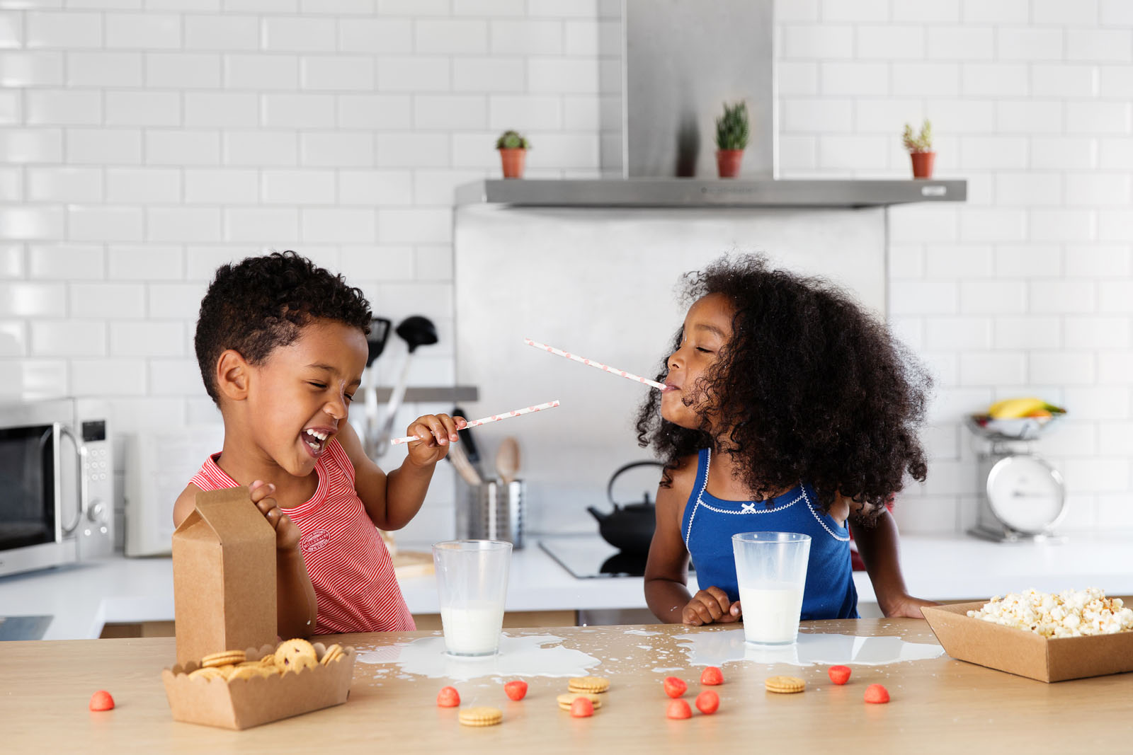 Children playing at home while creativity happens in the background